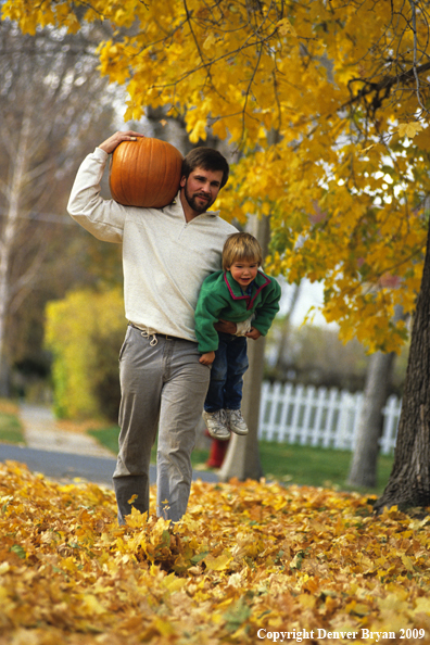 Father Carrying Child and Pumpkin