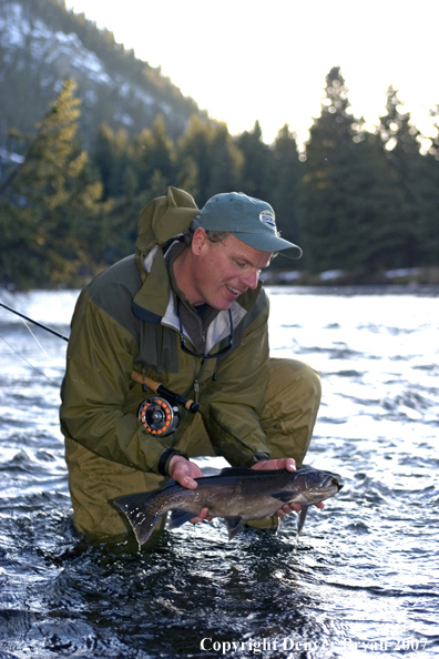 Flyfisherman releasing rainbow trout.