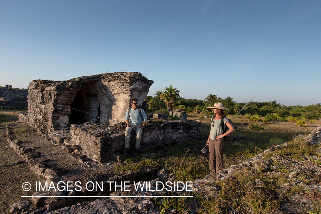 Flyfishermen walking through ruins to fishing location.