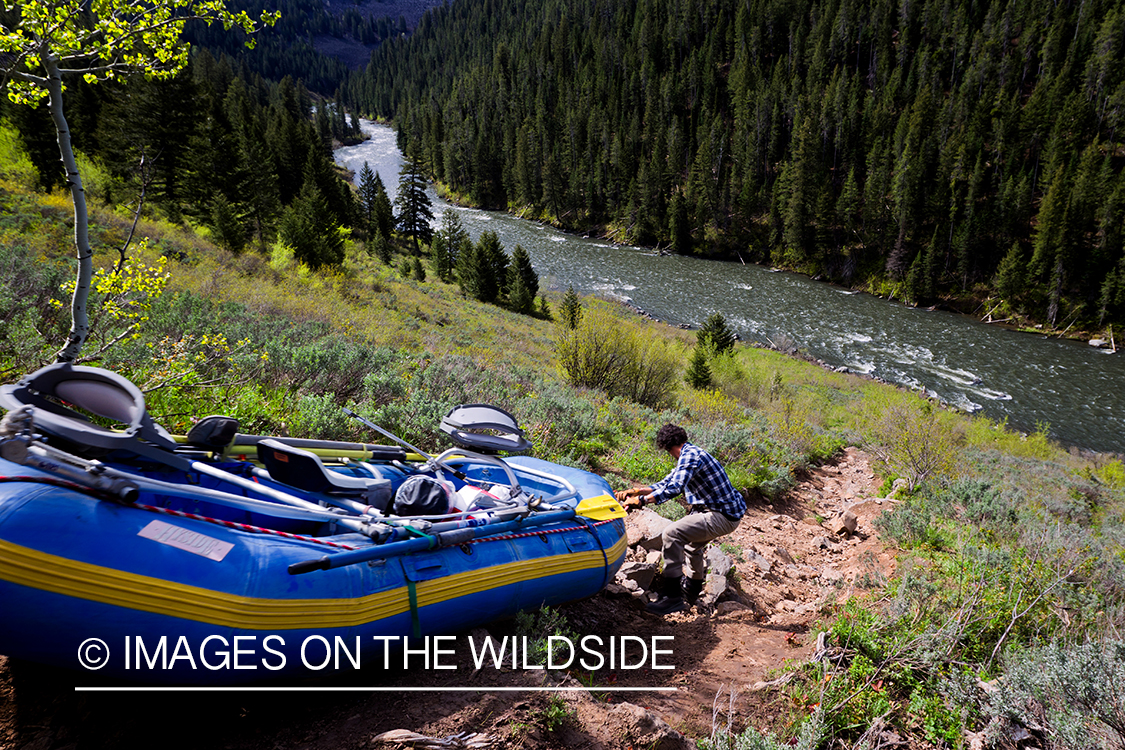 Flyfisherman taking raft to river.