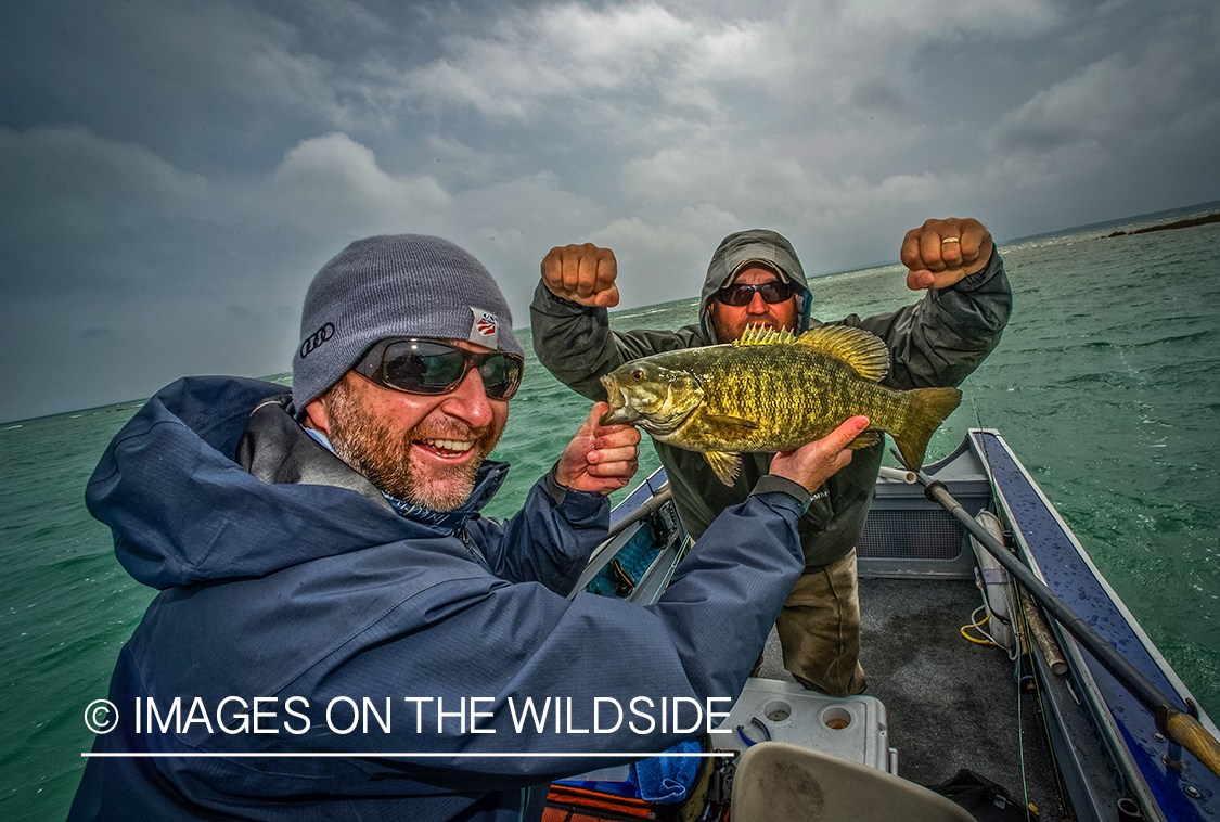 Fishermen with smallmouth bass in boat.