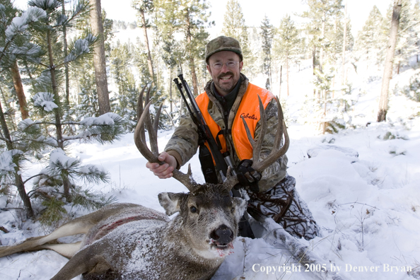 Mule deer hunter with downed buck.