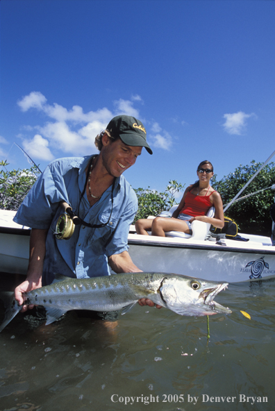 Saltwater flyfisherman with barricuda, woman on boat.