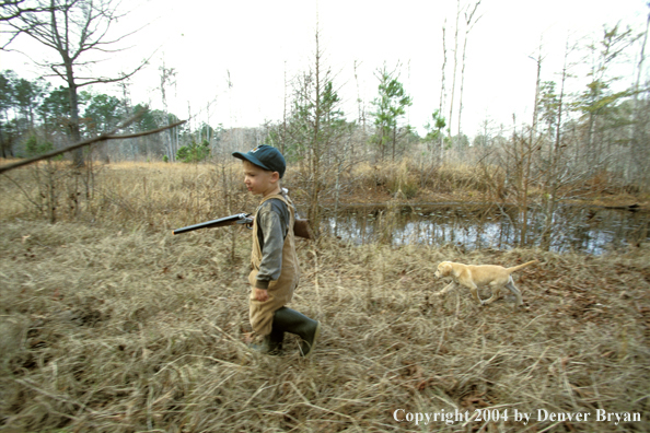 Young hunter with yellow Lab pup.