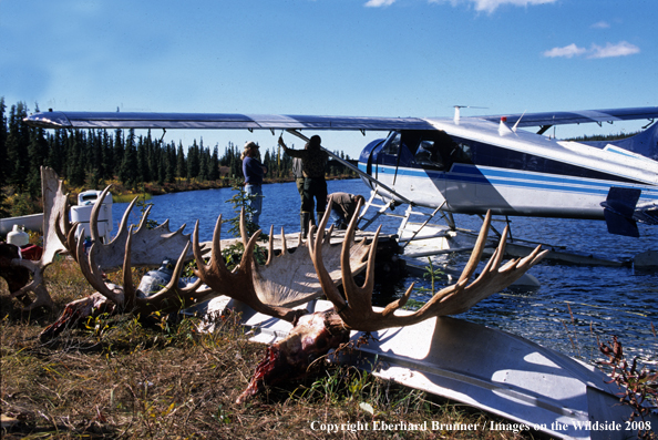 Moose hunters standing by float plane