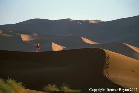 Woman running on sand dunes in Sossusvlei park, Namibia. Africa