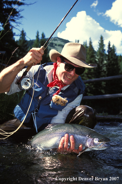 Flyfisherman holding rainbow trout.