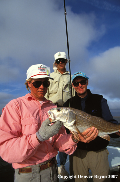 Saltwater flyfishermen holding redfish.