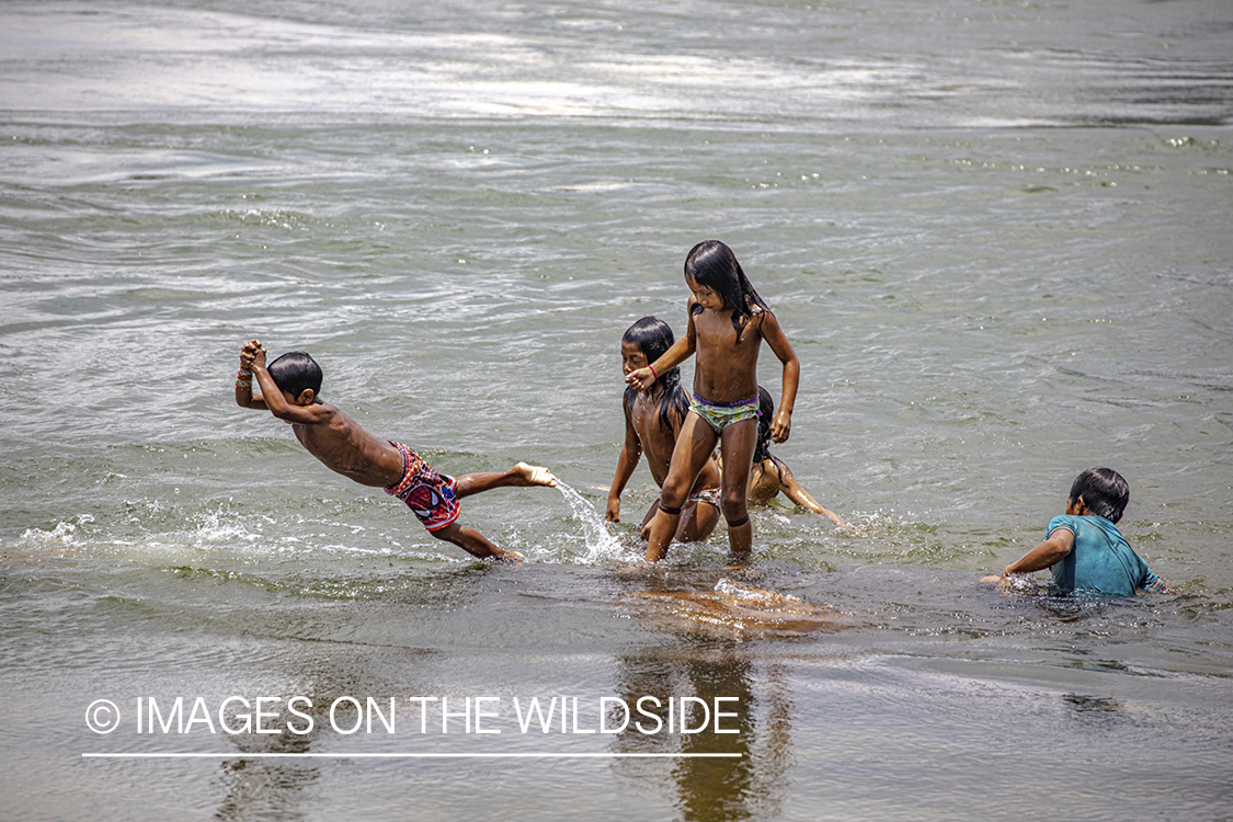 Native children playing in water.