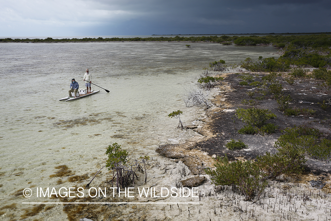 Flyfishermen on stand up paddle board on flats.