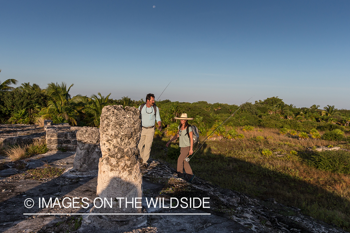 Flyfishermen walking through ruins to fishing location.