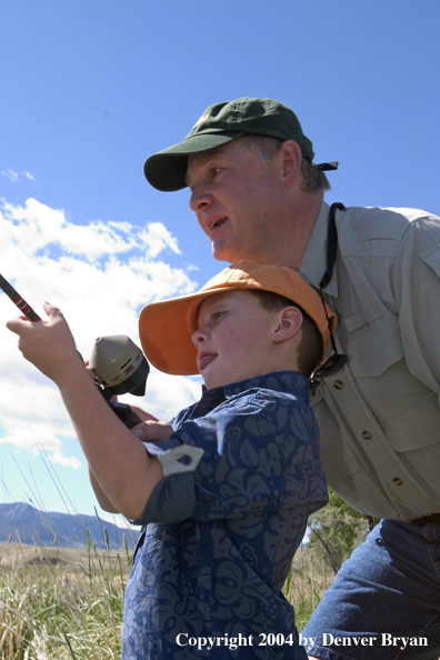 Father helping son spincast fishing.