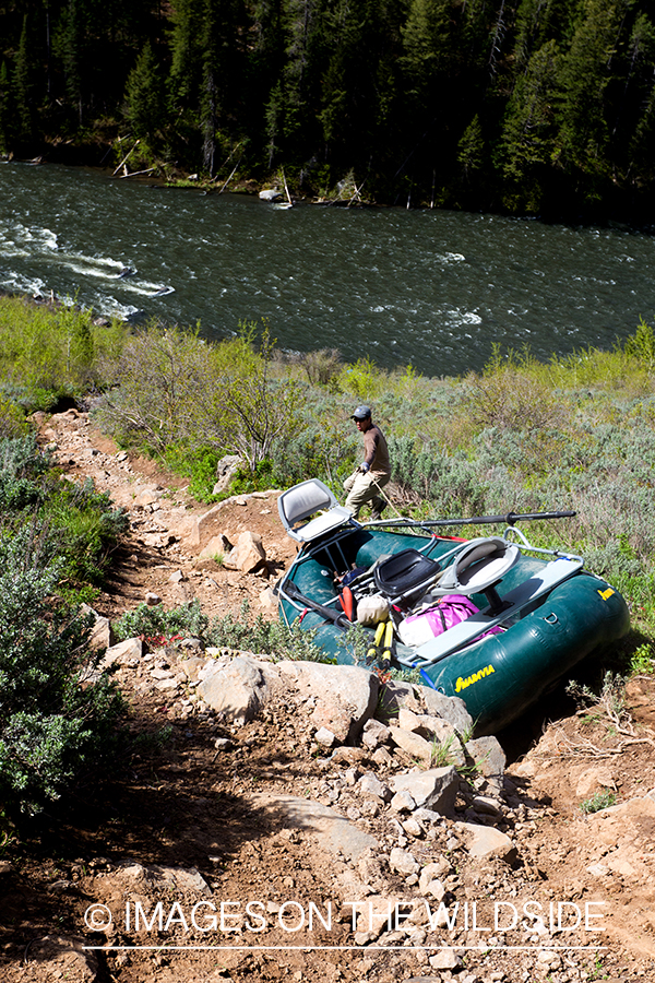 Flyfisherman taking raft to river.