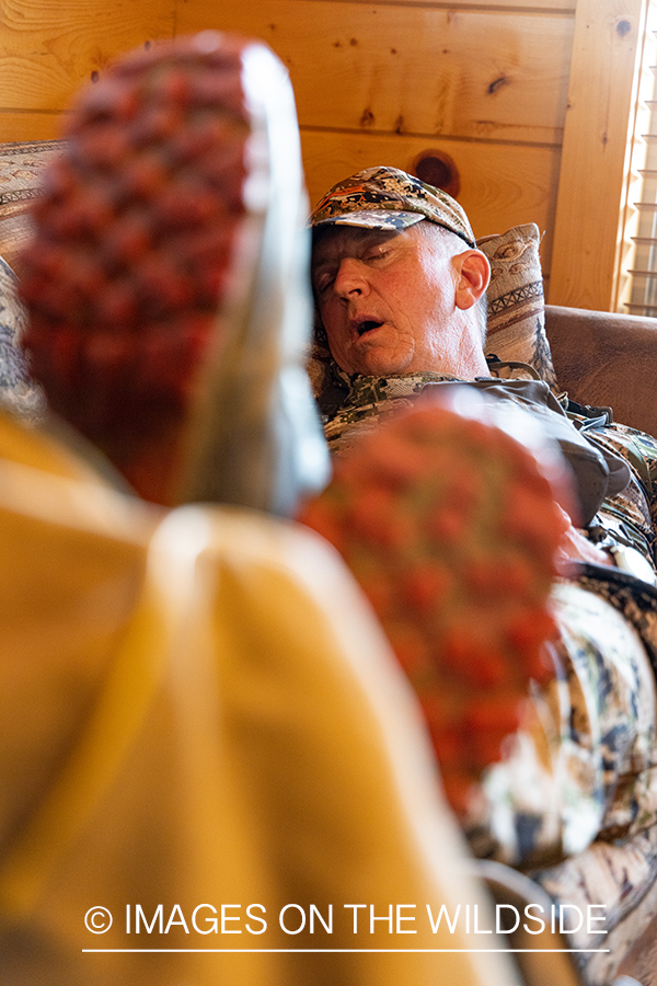 Turkey hunter asleep in cabin.