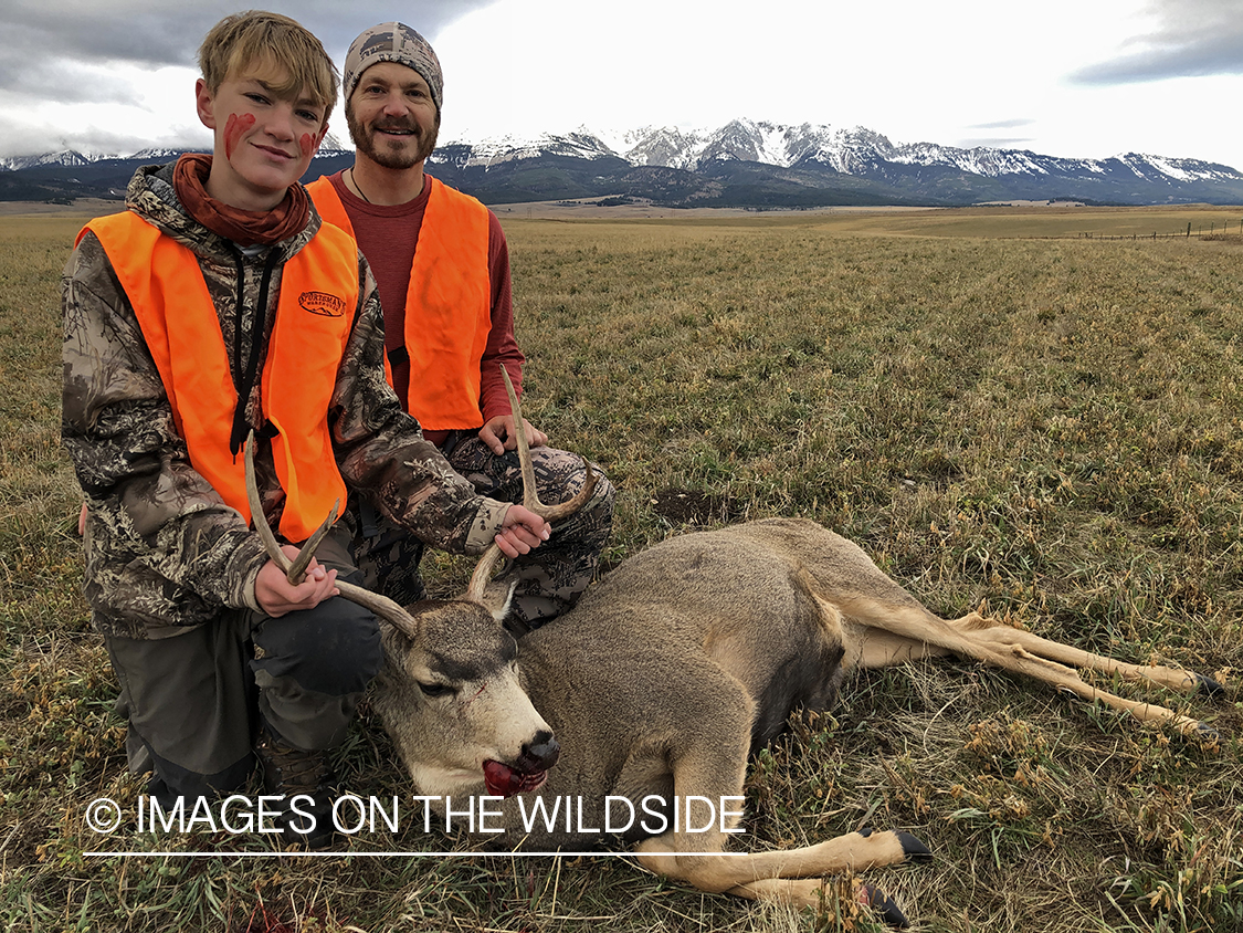 Father and son with downed mule deer.