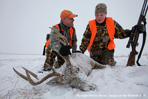 Father and son with son's downed white-tail buck 