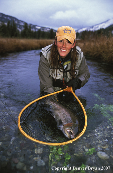 Woman flyfisher with brown trout.