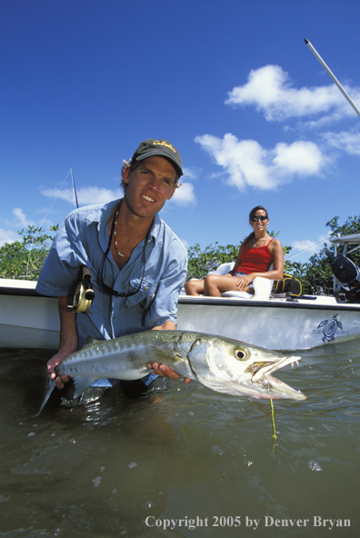 Saltwater flyfisherman with barricuda, woman on boat.