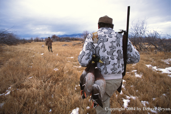 Waterfowl hunters with bagged ducks.