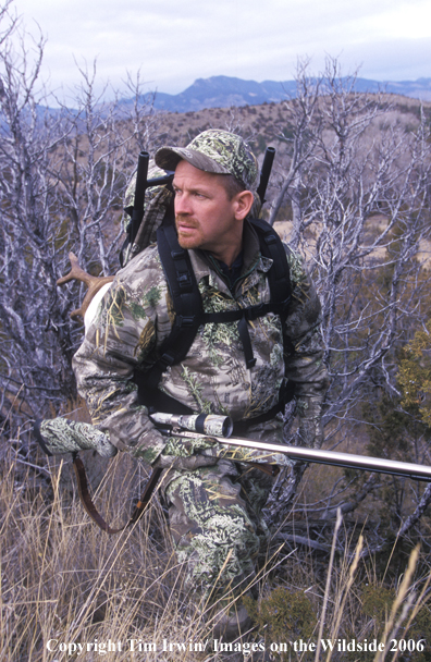 Big game hunter with mule deer horns on back.