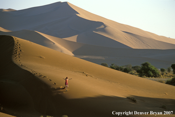 Woman running on sand dunes in Sossusvlei park, Namibia. Africa