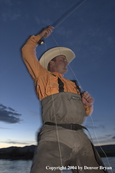 Flyfisherman playing fish at dusk (MR)