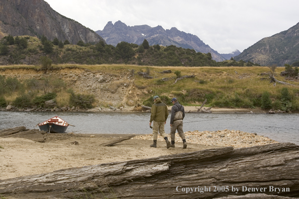 Flyfishermen walking to driftboat. 