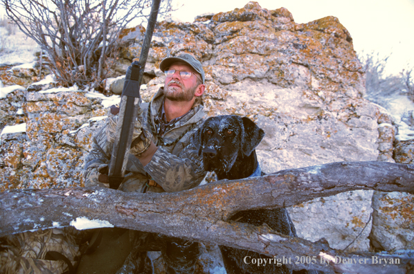 Waterfowl hunter with black Lab.