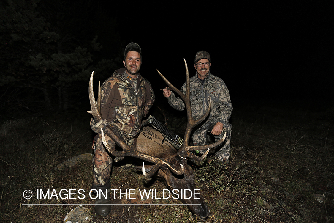 Hunter and guide with down bull elk. 