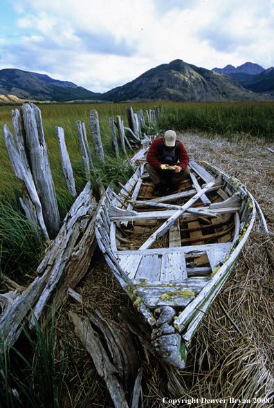 Flyfisherman sitting in old boat