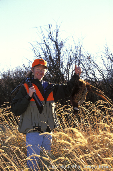 Upland game bird hunter with bagged pheasant.