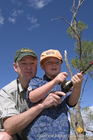 Father helping son spincast fishing