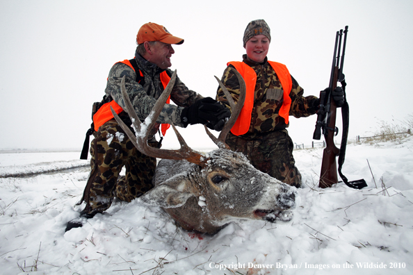 Father and son with son's downed white-tail buck 