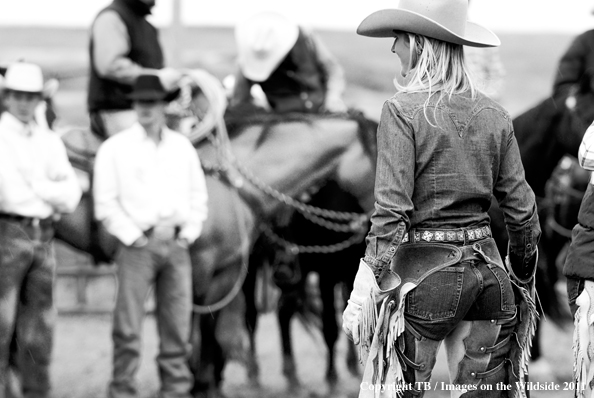 Cowgirl walking toward cowboys