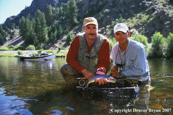 Flyfisherman holding cutthroat/rainbow trout.