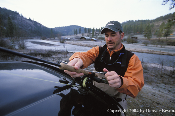 Flyfisherman taking rod off car rack.