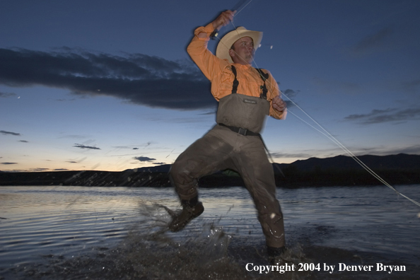 Flyfisherman playing fish at dusk (MR)