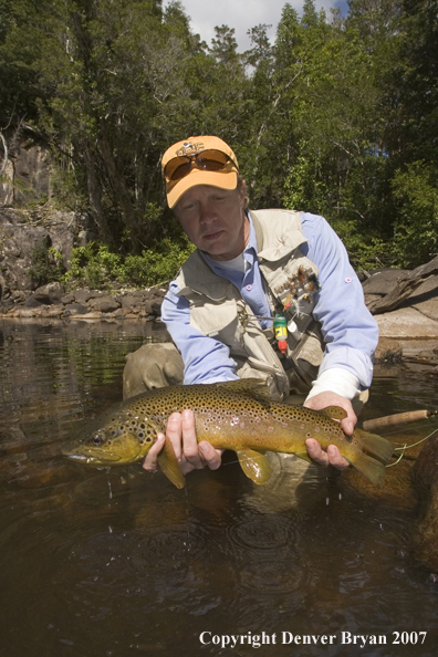 Flyfisherman holding nice brown trout.