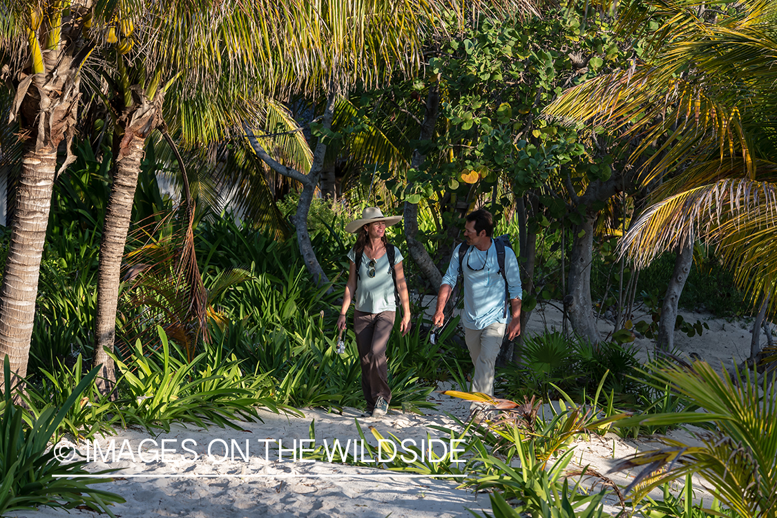 Flyfishing couple walking on beach.