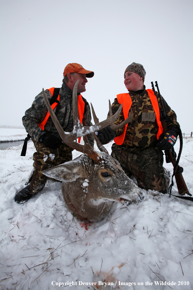 Father and son with son's downed white-tail buck 