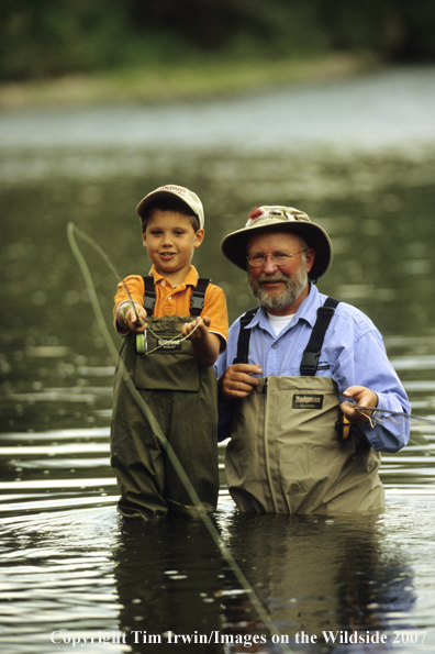 Grandfather teaching grandson how to fish