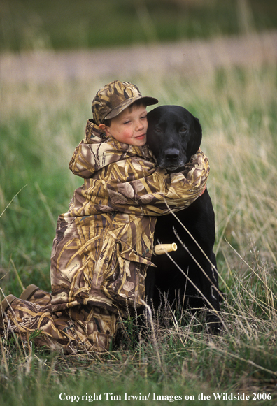 Black Labrador Retriever with young boy.