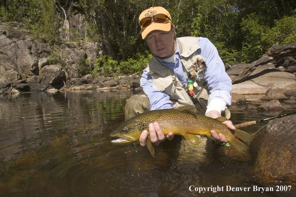 Flyfisherman holding nice rainbow trout.