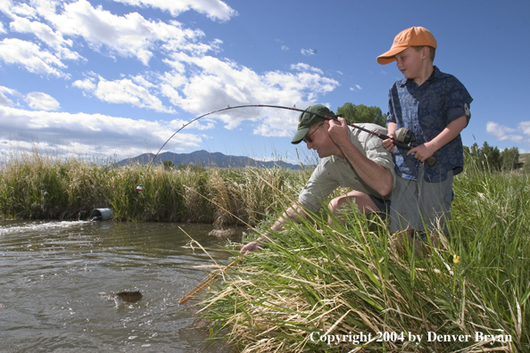 Father helping son land fish