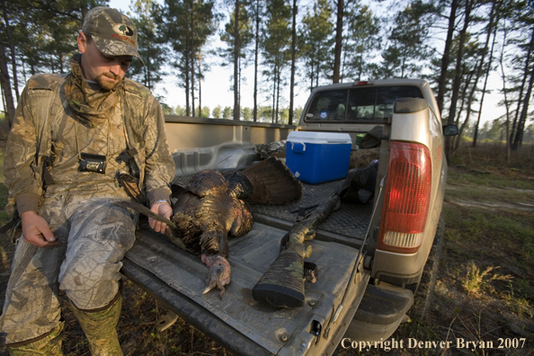 Turkey hunter in field with bagged bird