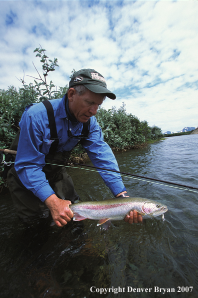 Flyfisherman holding rainbow trout.