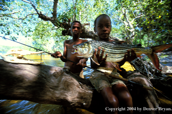 Child holding African tigerfish.