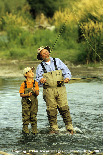 Grandfather teaching grandson how to fish