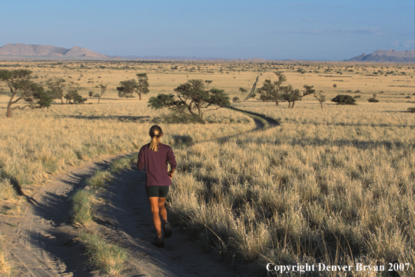 Woman running on road, Namibia. Africa.