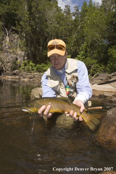 Flyfisherman holding nice brown trout.